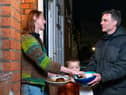 Adam Walters with his son delivering potatoes to one of his neighbours in Lloyds Park, Walthamstow.  