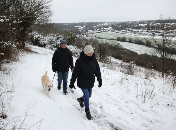 <p>A couple walk their dog in the snow at Dartland Banks nature reserve near Hampstead.</p>