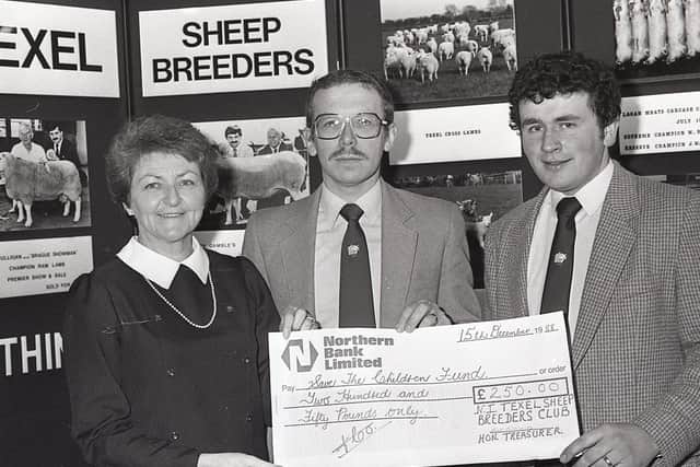 David Irwin, chairman of the Northern Ireland Texel Sheep Breeders' Club, and Nigel Hamill, vice chairman, present a cheque for £250 to Mrs Pat Millar from Save the Children at the Winter Fair at the King's Hall in December 1988. Picture: Trevor Dickson/Farming Life/News Letter archives