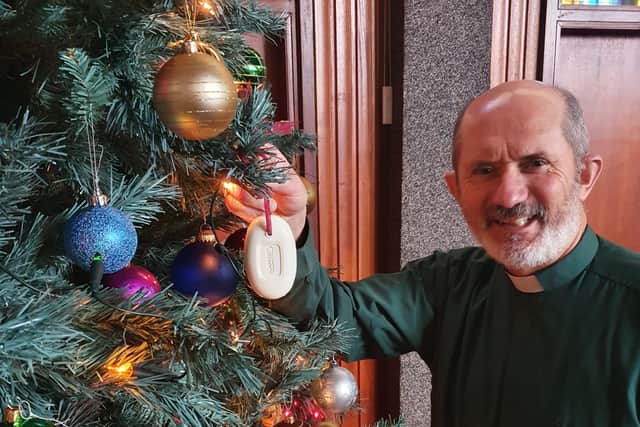 Rev Colin McClure, minister at First Larne Presbyterian Church in County Antrim hangs soap on his Christmas tree to symbolise the hope that soap can beat both the virus and extreme poverty.