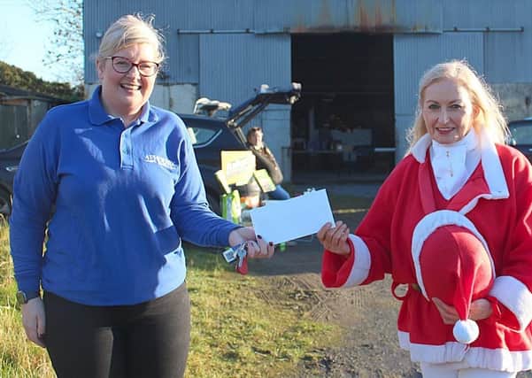 Gillian Orr from Phoenix Gas presents Joan Cunningham, organiser of the Saintfield Christmas Charity Ride with a substantial cheque