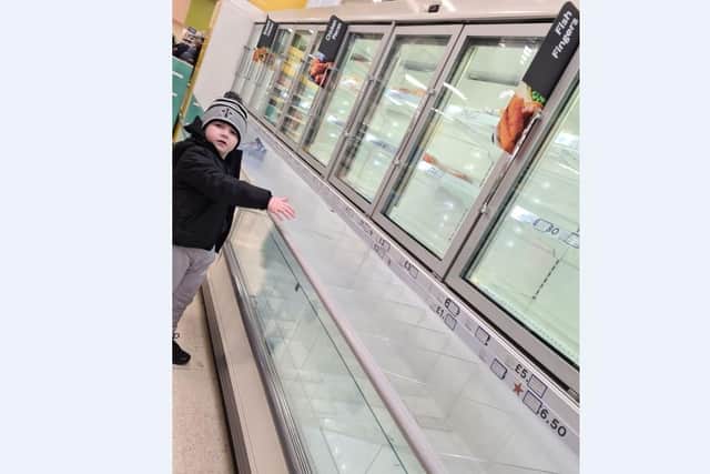 Seán "g Toman aged 7 beside empty freezers in Tesco, Craigavon.