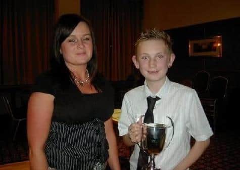 Young James Greer collects the Sennen Cove 2 Bird Ave Cup from Jennifer McCloy the wife of Cullybackey Chairman Harry at the annual prize night.