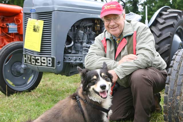 Robert McMaster and his dog Laddie, pose in front of the vintage tractors. TT30-138JS