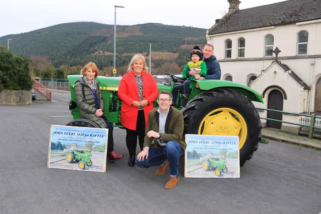 The Sloan family bring Francis' John Deere 1020 to present to the winner, l-r Rosemary, Orla, David, Grandson Daithi and Conor. It was Francis’ dying wish to raise money for Life and Time and S.A. Hospice and they each received £20,250.