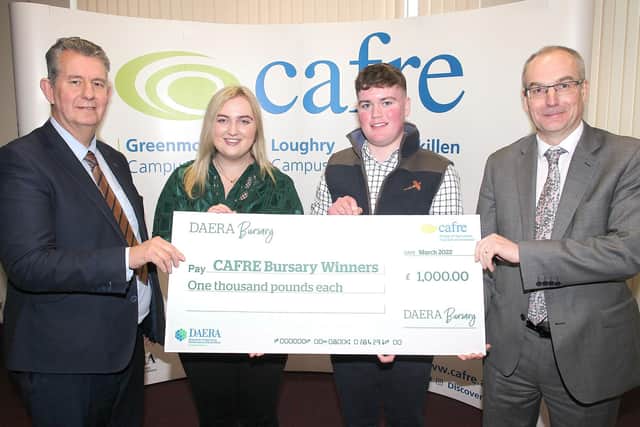 DAERA Minister Edwin Poots presents special centenary bursaries to CAFRE students (l-R) Hannah Jordan and Caleb Orr. He is joined by CAFRE Director Martin McKendry.