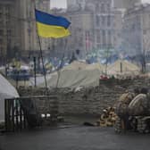 Anti-Yanukovych protesters warm themselves next to a fire in Kiev's Independence Square, Ukraine, Wednesday, March 5, 2014. Stepping back from the brink of war, Vladimir Putin talked tough but cooled tensions in the Ukraine crisis Tuesday, saying Russia has no intention "to fight the Ukrainian people" but reserves the right to use force. As the Russian president held court in his personal residence, U.S. Secretary of State John Kerry met with Kiev's fledgling government and urged Putin to stand down. (AP Photo/Emilio Morenatti)