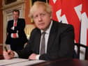 UK chief trade negotiator, David Frost looks on as Prime Minister Boris Johnson signs the EU-UK Trade and Cooperation Agreement at 10 Downing Street, Westminster. PA Photo. Picture date: Wednesday December 30, 2020. See PA story POLITICS Brexit. Photo credit should read: Leon Neal/PA Wire