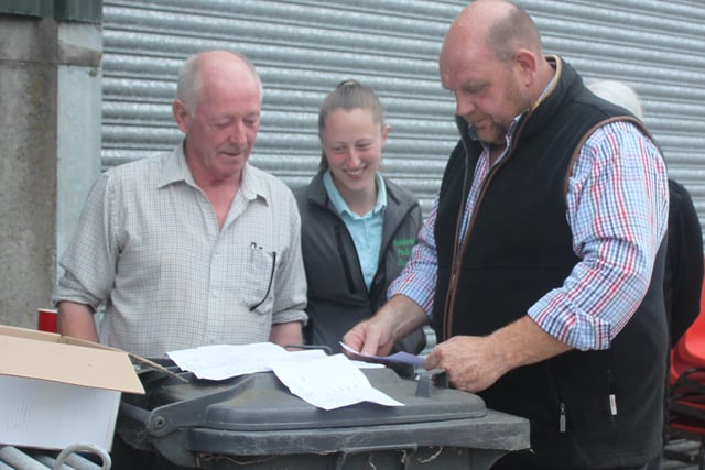 Hosts Harold and Rebecca McBratney marking the Stock judging cards with Judge William McAllister