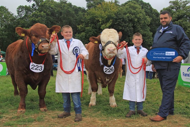 Brothers Jamie and Lewis Dodd, Saintfield, won first and second in the junior beef young handler class at the Randox Antrim Show. They are pictured with Denis Hunter, Danske Bank. Picture: Julie Hazelton/McAuley Multimedia
