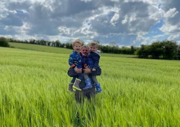 Andrew Sloane with his grandsons Tommy and Daniel in his winter barley in Armagh.