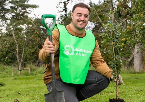 Self Help Africa Northern Ireland Ambassador Rob Herring plants a tree for the charity