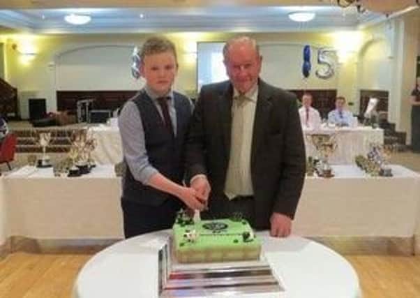 Thomas Boyd cutting the cake at 85th anniversary of Ahoghill YFC