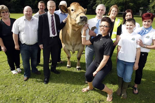 Beautician Claire Godfrey gives a cow some lipstick as Gregory Campbell and Councillor Adrian McQuillan and event organisers enjoy a laugh at the United Parthenaise Cattle Society Show at Garvagh in August 2010. Picture: Farming Life archives