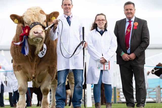 Judge Robin Boyd, Portglenone, congratulates Richard Rodgers and Megan McKane, who exhibited the supreme overall champion on behalf of James McKane. Picture: Mullagh Photography