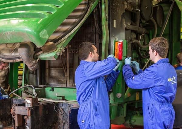 Land-based Engineering students completing maintenance on the harvester at Greenmount Campus