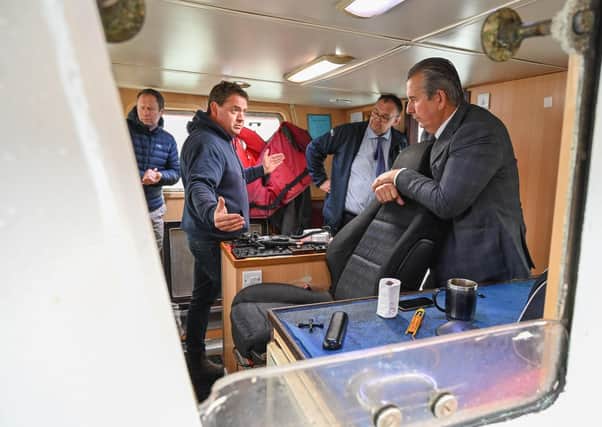 Darren McClements, owner of the fishing vessel Golden Ray, chats with DAERA Minister Edwin Poots about the benefits of the innovative on-board equipment for handling his catch of prawns that he has bought thanks for funding from a DAERA pilot scheme