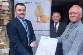 Peter Morgan, Chairman of the Poultry Industry Education Trust, presents the annual Poultry Industry Education Trust  award, a Times Atlas of the World and inscribed memento to Wilson McLeister from Portglenone. Looking on is Basil Bayne, a Fellow of Harper Adams University and PIET Trustee.