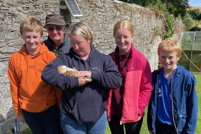 Nature-friendly farmer Dawn Stocking, her children, and father William Bassett, delight at one of the three barn owl chicks which successfully hatched at Ballycruttle Farm this summer, providing a welcome new nest site in Northern Ireland for this priority bird.