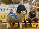 Harry Breen accepts the Farmcare Reserve Champion rosette on behalf of his dad, Alistair Breen from judge Frank Clewer and sponsor Mark Crawford Farmcare for his Drumderg exhibit at the NI Texel Sheep Breeder’s Club Show & Sale in Enniskillen.