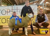 Harry Breen accepts the Farmcare Reserve Champion rosette on behalf of his dad, Alistair Breen from judge Frank Clewer and sponsor Mark Crawford Farmcare for his Drumderg exhibit at the NI Texel Sheep Breeder’s Club Show & Sale in Enniskillen.