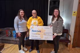 Club secretary Joanna Caughey and treasurer Hayley Russell handing over the charity cheque to Robin McConnell from Marie Curie. Picture: Donaghadee YFC