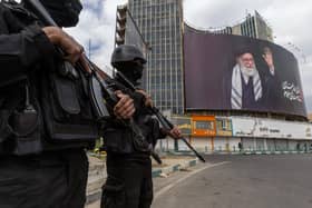 Security forces stand guard near a portrait of Ayatollah Ali Khamenei on March 2, 2026 in central Tehran, Iran. Iran's Supreme Leader, Ayatollah Ali Khamenei, was confirmed killed after the United States and Israel launched a joint attack on Iran on February 28. Iran retaliated by firing waves of missiles and drones at Israel, and targeting U.S. allies in the region. (Photo by Majid Saeedi/Getty Images)