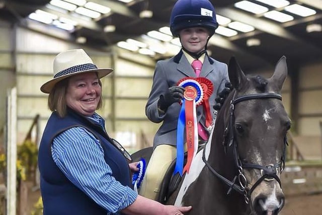Jan Martin presents Paige Erwin and Henry with their Champion Pony rosette. (Pic: Equi-Tog)