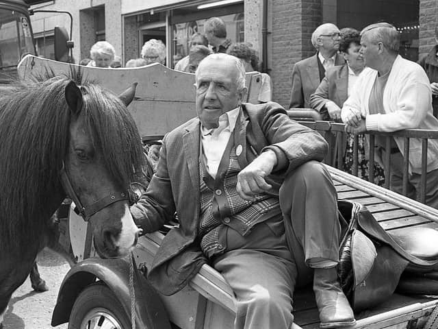 Pictured in May 1992 amidst the hustle and bustle of the Ballyclare May Fair is horse dealer George Rainey from Drumbeg, Lisburn, who is seen relaxing from his toil on the back of a convenient cart and as he watches the world go by. Picture: News Letter archives/Darryl Armitage