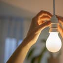 Hands replacing a light bulb