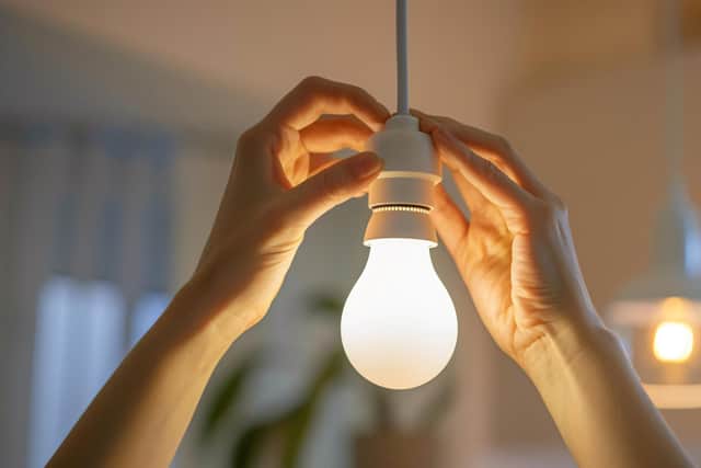 Hands replacing a light bulb