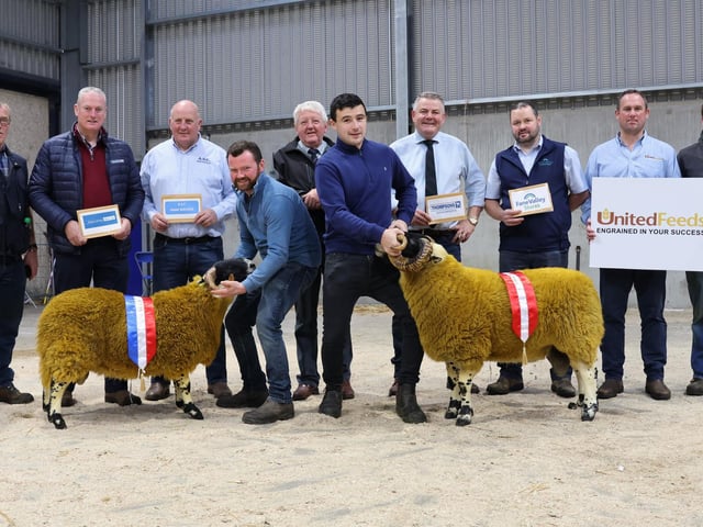 (front row) Champion of Champions and Reserve Champion of Champions from Tom, Joe and Archie Adams, held by Archie Adams and Shane Morrow. (back) Tom Adams, Seamus Mc Cormick, Danske Bank, Alan Carson, ASC Farm Services, Ian Watson, URBA Blackface Chairman, Thomas Harkin, Thompsons Feeding Innovation, Seamus Mullan, Fane Valley Stores, Mark Bruce, United Feeds and Joe Adams.