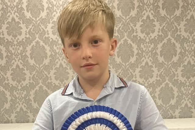 Jayden McCutcheon proudly displaying the Reserve Champion Large Flock rosette won by Bodoney Flock, Trillick.