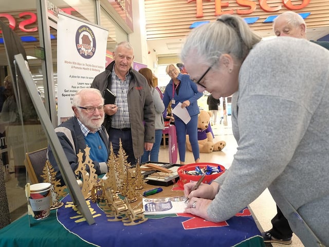 Alan Kinghan (North Belfast Men's Shed) talking to shoppers at the community event.