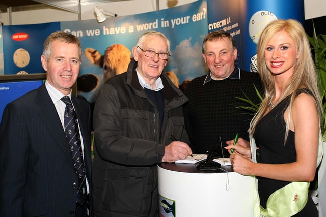 Joe Crawford, left, Fort Dodge and Miss Newry, Laura McCausland, help Robert McKay and George Stewart, Portglenone, enter the draw on the Fort Dodge stand at the Winter Fair.