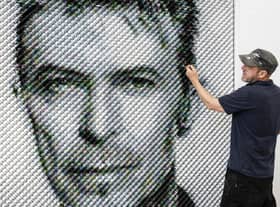 Artist Joe Black adds the finishing touches to a portrait of David Bowie made from over 8,500 guitar plectrums, commissioned by Sky Arts to celebrate Bowie topping a new definitive list of Britain's 50 most influential artists of the past 50 years