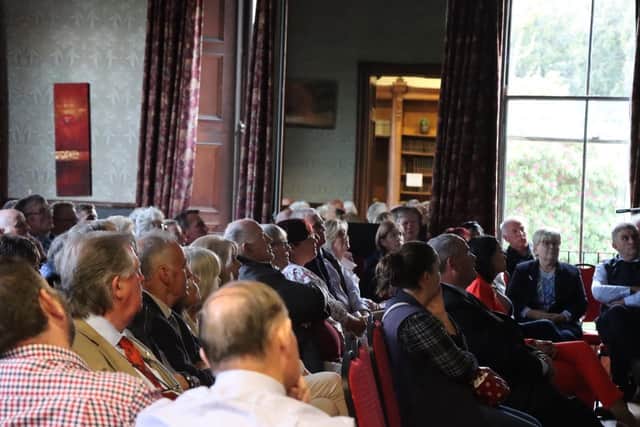 Show guests enjoying the guest speaker in the beautiful castle ballroom.