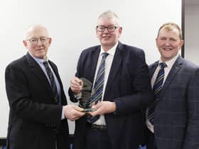 John Martin, Kesh, receives his Long Service Award from Michael Smale, left, chaiman, Holstein UK; and vice-chairman Wallace Gregg. 