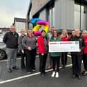 Store managers from the 10-store fundraising initiative presenting the cheque to Joanne Young from Macmillan Cancer Support