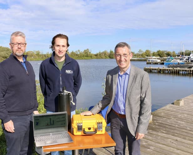 DAERA Minister Andrew Muir launches the second phase of the Lough Neagh Water Quality Dashboard in Ballyronan pictured with (L-R) Patrick Murphy, Lough Neagh Science Advice Branch, DAERA and Stephen Prentice, NIEA Freshwater Monitoring and Assessment.