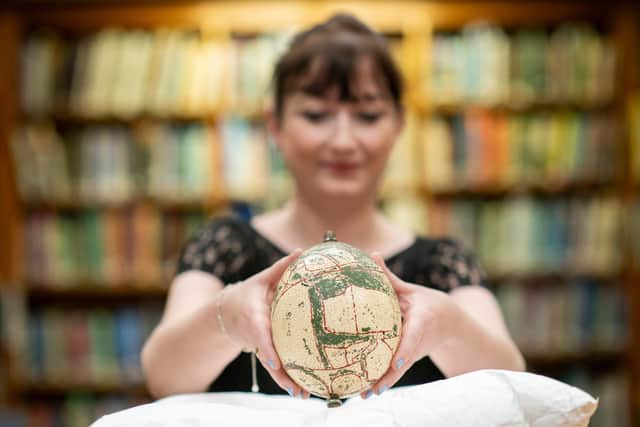 ZSL archivist Natasha Wakely holds a 1930s ostrich egg, decorated with a map of Whipsnade Zoo and once owned by the first Whipsnade Zoo superintendent, Captain W P Beal © Jas Lehal, PA