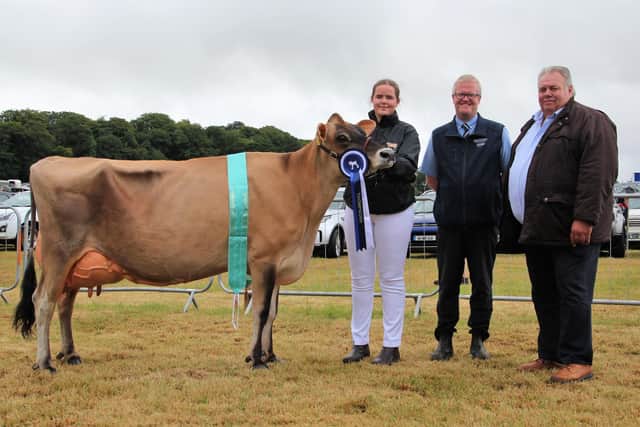 Ronald Annett (Thompsons) and Kenneth Boyd (judge) congratulate Ailsa Fleming, Seaforde, with the fourth calver Potterswalls Impression Magic 2 EX91, who qualified for the 2023 Thompsons/NISA Dairy Cow Championship at Castlewellan Show. Pic: Thompsons