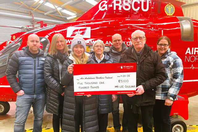 Pictured is Lee Gilliland’s family (left to right), Colin, Shirley, Zoe, Eileen, Graeme, William & Lynne presenting a cheque for £5,100 at the Air Ambulance NI base in Lisburn.