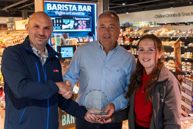 Robert Caughey, Regional Sales Manager at Henderson Group, presenting Peter McBride with an anniversary plaque, alongside Peter’s daughter, Ava McBride. Pic:jcomms