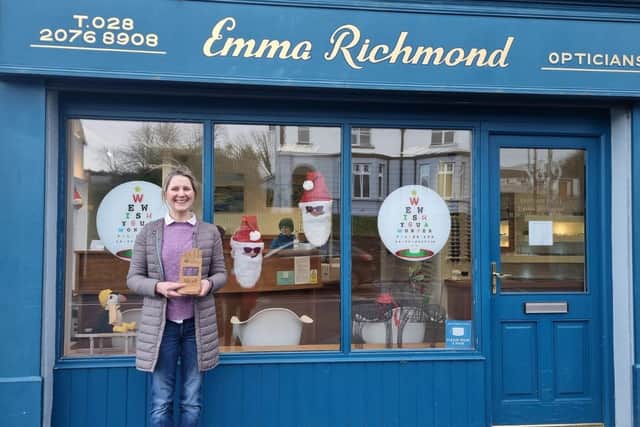 Emma Richmond of Emma Richmond Opticians, with her trophy for best Ballycastle Christmas Window, showing that Santa shops local and looks cool in his sunglasses