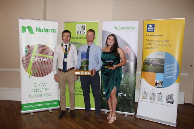 BGS President Philip Cosgrave (left) presents the trophy to BGS Grassland Farmer of the Year 2023 Robert Black, and his wife Rachel.