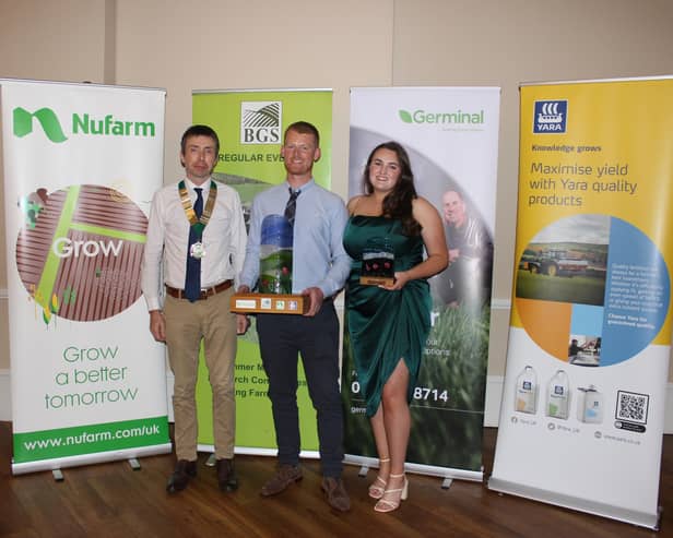 BGS President Philip Cosgrave (left) presents the trophy to BGS Grassland Farmer of the Year 2023 Robert Black, and his wife Rachel.