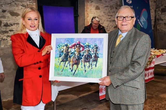 Saintfield Christmas Charity Ride organiser, Joan Cunningham, presents Terence McKeag with an original Leo Casement painting for his services to the Saintfield Christmas Charity Ride and Saintfield Horse Show. (Pic supplied by Joan Cunningham)