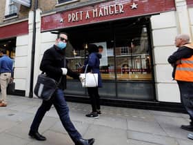 A man wearing PPE (personal protective equipment) passes customers queuing to enter a recently re-opened Pret-A-Manger shop which had originally closed-down due to the COVID-19 pandemic in London (Photo: TOLGA AKMEN/AFP via Getty Images)