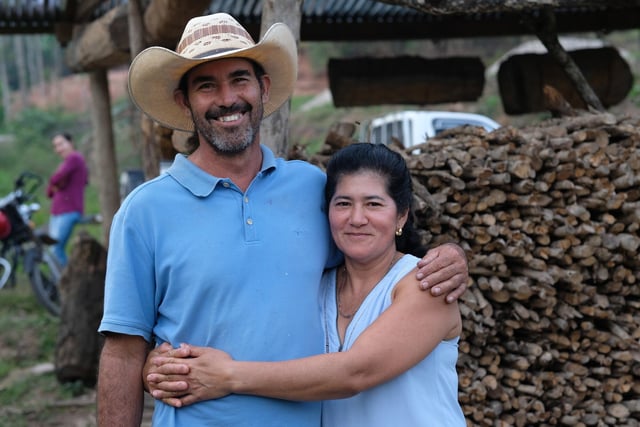 Juanita’s sister-in-law Maria Cruz pictured with her husband Jose Wilman Marquez with beehives hanging in the background. Maria was influenced by Juanita to start beekeeping. Credit: Amy Sheppey/Christian Aid.